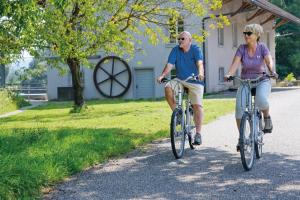 巴德楚尔察赫Dorint Parkhotel Bad Zurzach的骑着自行车沿着公路行驶的男人和女人