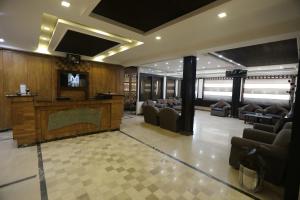 木尔坦City Centre Suites的大厅配有沙发和墙上的电视
