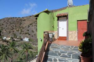 巴列埃尔莫索Casa La Hagar的一座带白色门和山的绿色房子