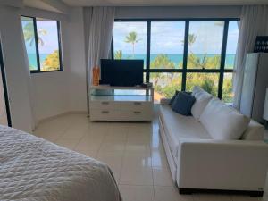 嘎林海斯港Marulhos Resort Flat Vista Mar的客厅配有白色沙发和电视