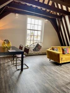 米德尔堡Torenkamer Middelburgh的客厅配有黄色的沙发和桌子