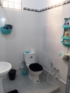 特莱姆森Joli Chalet plain-pied avec jardin privatif的浴室设有卫生间、黑色座椅和水槽。