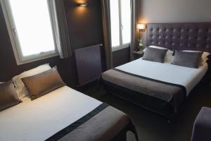 巴黎圣查尔斯酒店的酒店客房带两张床和两个窗户