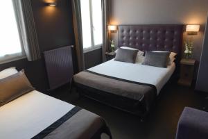 巴黎圣查尔斯酒店的酒店客房带两张床和两个窗户