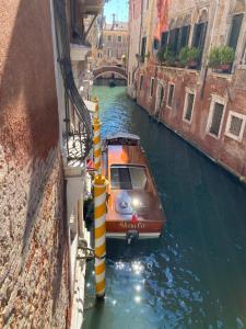 威尼斯鲁奇尼宫酒店的两栋建筑之间运河上的小船