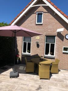 雷讷瑟Het Pronkje的庭院配有桌椅和遮阳伞。