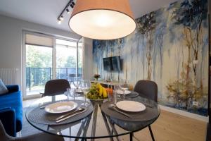 比亚韦斯托克Apartament Koncertowy的一间设有玻璃桌和椅子的用餐室