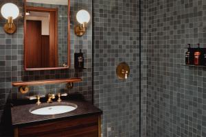 华盛顿哥伦比亚区伊顿酒店的蓝色瓷砖浴室设有水槽和淋浴