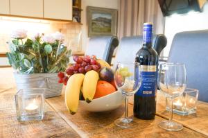萨彻姆Colthrop Manor with Gardens的一瓶葡萄酒和玻璃杯,一碗水果