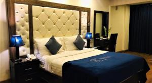 伊斯兰堡Atlas hotel的一间卧室配有一张大床和大床头板