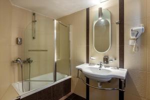 卡兰巴卡托蒂精品客房酒店的一间带水槽、淋浴和镜子的浴室