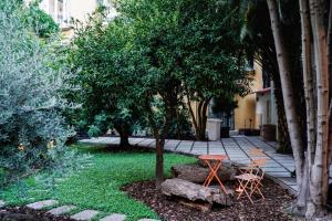那不勒斯NAP Hostel Spaccanapoli的花园配有桌子和两把椅子,还有一棵树