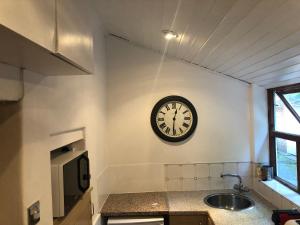 StocksfieldMole Cottage的墙上的时钟,厨房的墙上,有水槽
