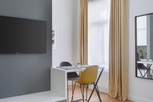 萨格勒布THE City Lodge - Boutique Apartments的客厅配有书桌和墙上的电视
