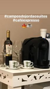 坎波斯杜若尔当Campos do Jordão Suites的一张桌子,上面放着两杯酒和一瓶葡萄酒
