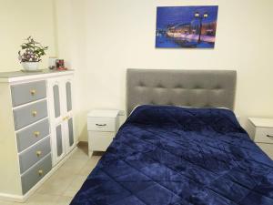圣多美Departamento Santo Tome centrico的一间卧室配有蓝色的床和梳妆台