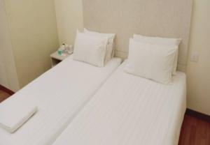 古晋1ACS Residence的配有2张床的带白色床单和枕头的客房