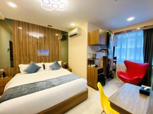 新加坡five6 Hotel Splendour的一间卧室配有一张床、一张桌子和一把红色椅子