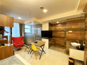 新加坡five6 Hotel Splendour的客厅配有桌椅和电视。