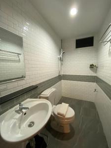 南府น่านลอฟท์รูมแอร์พอร์ต的白色的浴室设有水槽和卫生间。