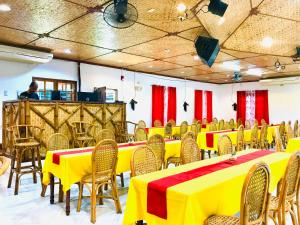 公主港快乐之源酒店的配有桌椅的房间,配有黄色和红色的桌布