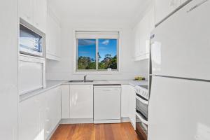 尼尔森湾Location @ Little Beach的白色的厨房配有水槽和冰箱