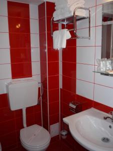 GiurgiuHotel Sud的红色和白色的浴室设有卫生间和水槽