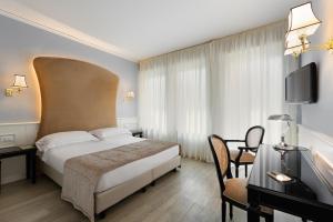 维罗纳圣卢卡酒店的酒店客房设有一张床、一张书桌和一台电视机。