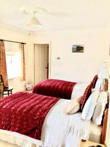 KillyleaghDufferin Coaching Inn的一间卧室配有一张带红色和白色枕头的大床