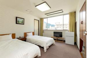 日光伊藤恩新樱花酒店 的酒店客房设有两张床和电视。