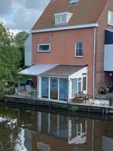 赞丹Characteristic detached house next to water的水体旁的房屋