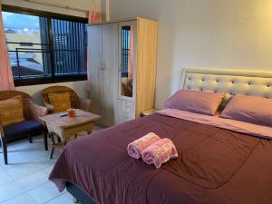 清迈班蓬潘公寓的一间卧室配有一张床、一张桌子和一个窗户。