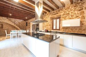 阿尔库迪亚Casa Sa Pedra, en el centro histórico de Alcudia的厨房设有石墙和炉灶。 顶部烤箱