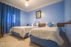 舍夫沙万塔里克酒店的一间卧室设有两张带蓝色墙壁的床