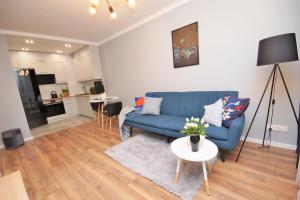 乔左维尔考普尔斯基Loft Apartament 1的客厅配有蓝色的沙发和桌子