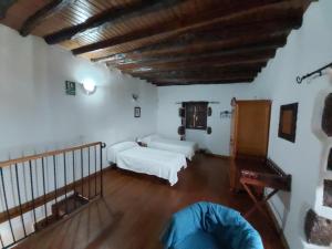 El Pinar del Hierro卡萨洛斯阿布罗斯酒店的一间带两张床和木制天花板的客厅