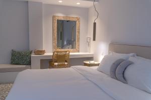 纳乌萨阿多尼斯公寓酒店的一间卧室配有一张床、镜子和椅子