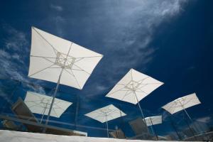 纳乌萨阿多尼斯公寓酒店的建筑顶部的一组白色雨伞