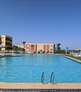 艾因苏赫纳Ain El Sokhna ground floor, with Pool & Sea view的一座大型游泳池,在一座建筑前设有两个金属把手