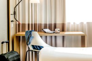 柏林柏灵米特宜必思酒店的客房设有带电话和椅子的书桌。