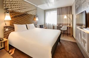 柏林柏灵米特宜必思酒店的酒店客房设有一张白色大床和一张书桌