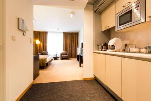 布鲁塞尔布鲁塞尔EU钻石套房公寓的酒店客房设有厨房和客厅。