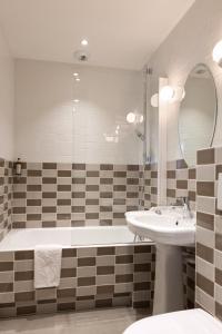 巴黎3普森酒店的带浴缸、水槽和镜子的浴室