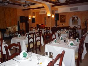 GiurgiuHotel Sud的用餐室配有桌椅和白色桌布