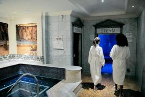 纽波特凯尔特庄园度假村酒店的两名妇女站在一个带浴缸的浴室
