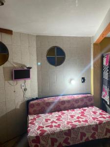 阿拉亚尔-杜卡布Hospedagem Mariano的一间卧室配有一张带红白毯子的床