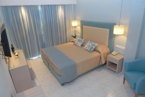 帕莱欧卡斯提撒奥德修斯酒店的一间小卧室,配有一张床和一张蓝色椅子