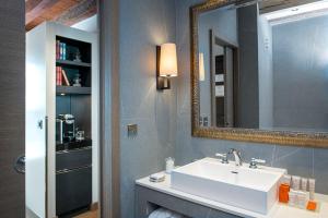 日内瓦Hôtel Les Armures的一间带水槽和镜子的浴室