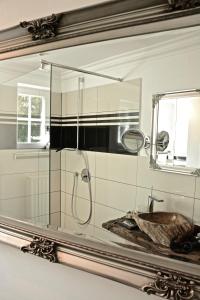 阿尔斯费尔德VILLA ADELEes BOUTIQUE HOTEL的浴室镜子配有水槽和淋浴