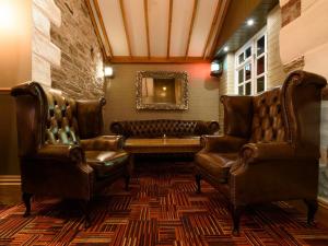 帕The Britannia Inn & Waves Restaurant的一间设有皮椅和沙发的等候室